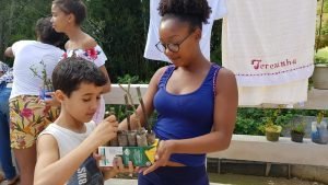 Jovem do projeto Futuro do Rio Doce entrega muda de planta para criança